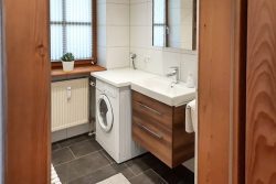 bathroom with walk in shower, mirror cabinet and washing machine with dryer